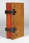 Anonym Non Book – Faux Book – Reliquiar aus Holz in Buchform. Von außen betrachtet ein Holzobjekt in Buchform mit Deckeln, Messingschließen und -haften, dreiseitigem Rotschnitt und Kapitalbändchen. Aufgeklappt enthüllt sich unter Glas ein sorgfältiges gefertigtes Reliquiar auf dessen grünem Seidengrund eine zentrale, ovale, farbige und goldgehöhter Fayence, wohl Maria darstellend, sowie zahlreiche, durch Papierstreifen beschrifteten Reliquien montiert sind. Dazwischen fast flächendeckend zahlreiche, mit Goldschnitt versehene sogenannte „Paperolles“, die florale Ornamente und ein Herz formen.